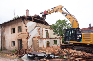 Photo of an excavator demolishing an old building