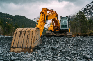 Large excavator scooping gravel in the mountains