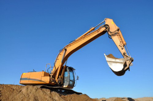 Excavtor scooping dirt with blue sky in the background